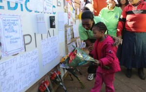 A girl places flowers next to messages outside the hospital where former South African President Nelson Mandela was being treated in Pretoria.