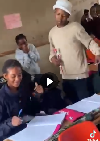 Male Student Gifts Girlfriend Flower While In Class, Hugs Her Tight As Classmates Cheer (Watch Video)